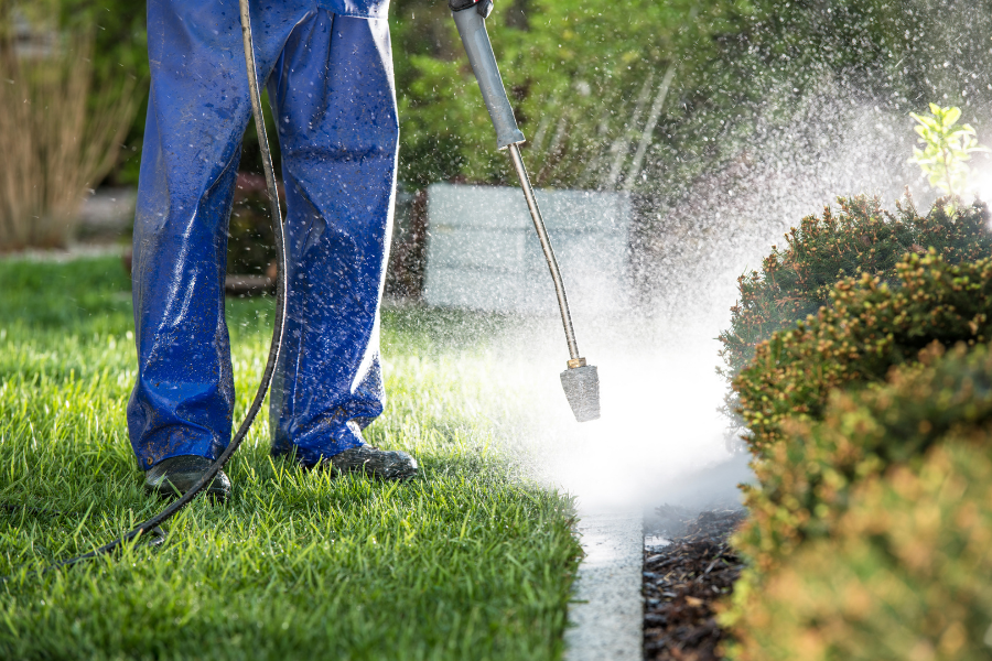 Man Cleaning Garden Bed Wall With Pressure Washer